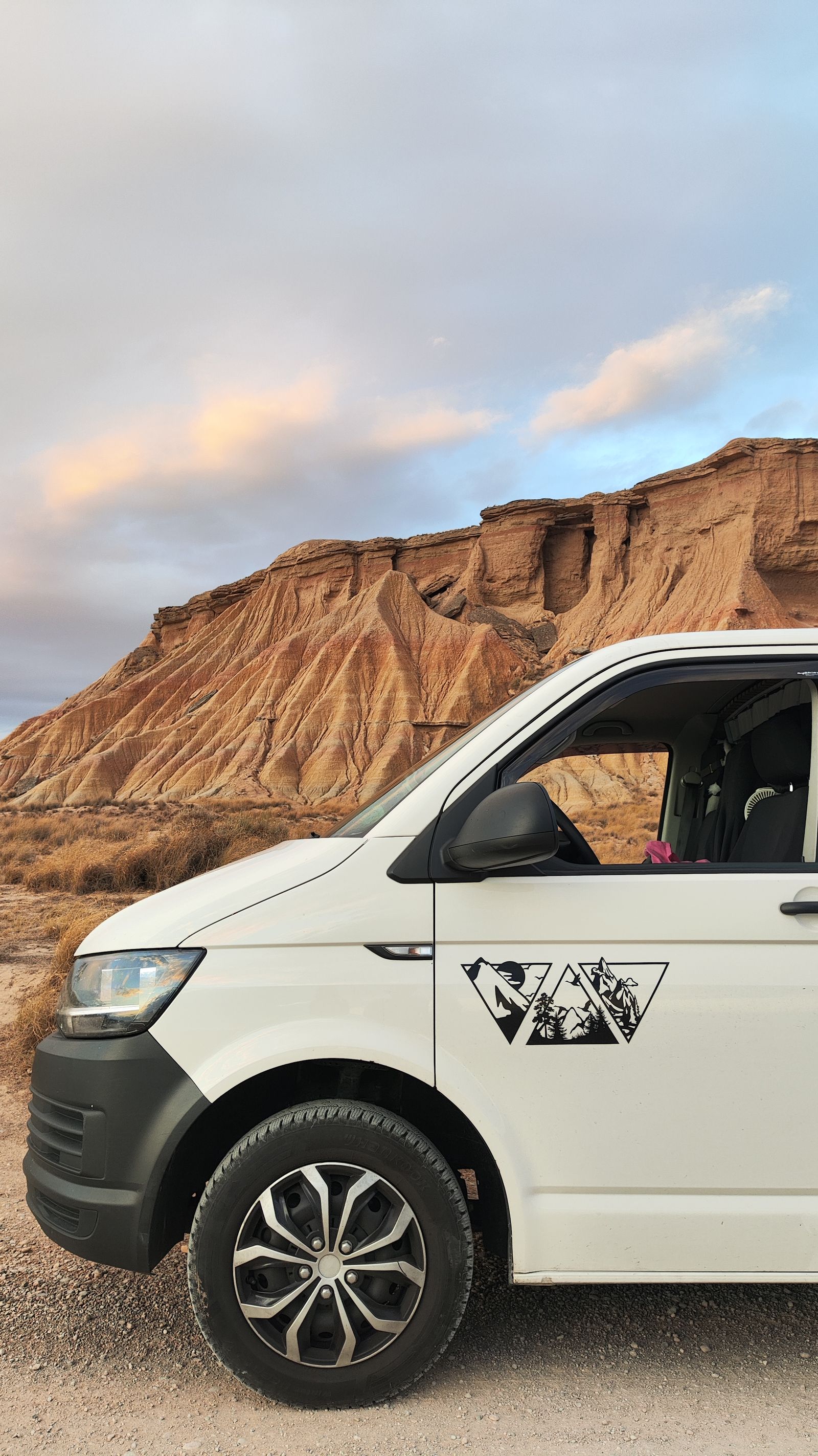 La MakakoVan aparcada al atardecer frente a las formaciones de arenisca de las Bardenas Reales.